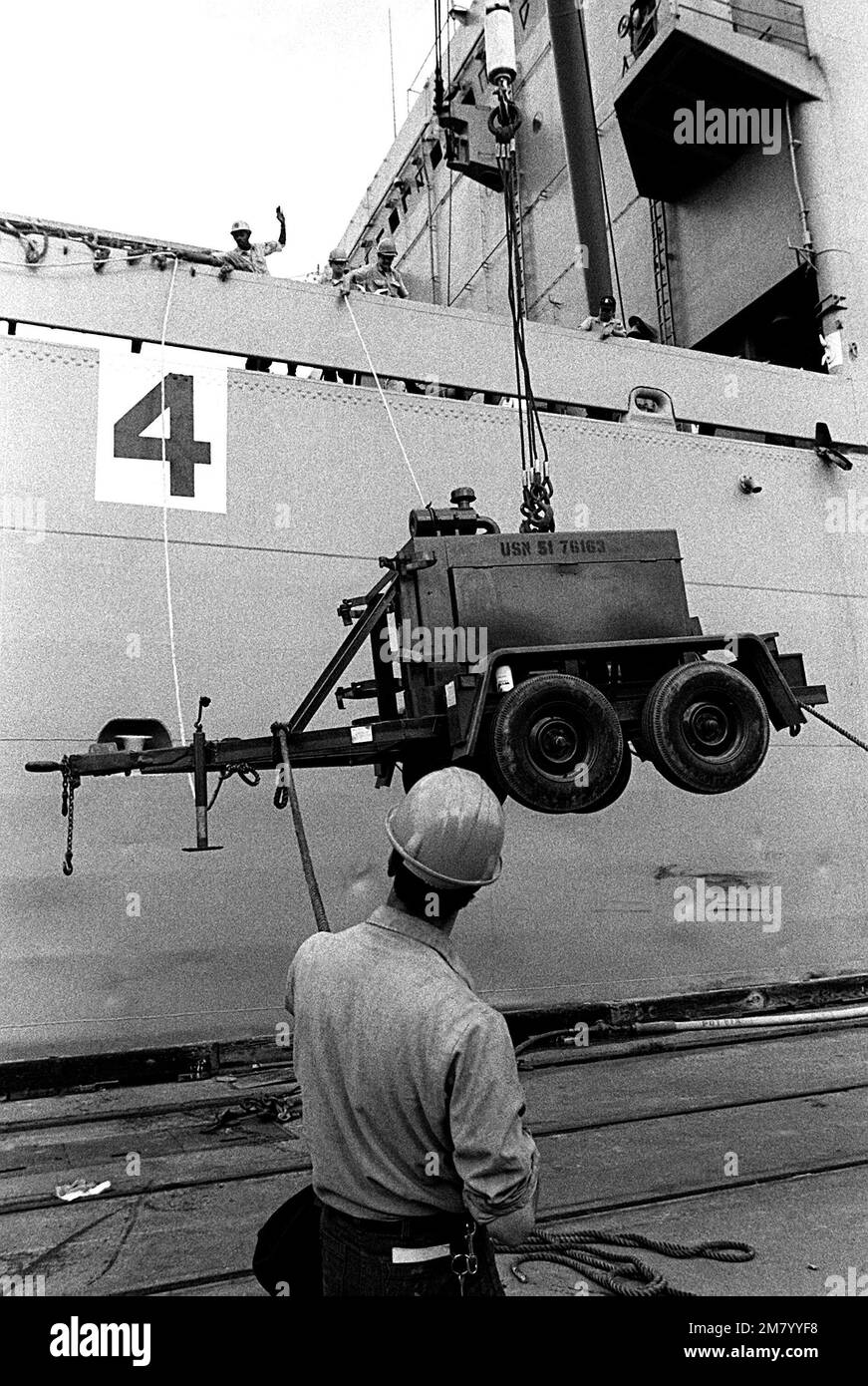 Seabees load heavy equipment aboard the amphibious cargo ship USS