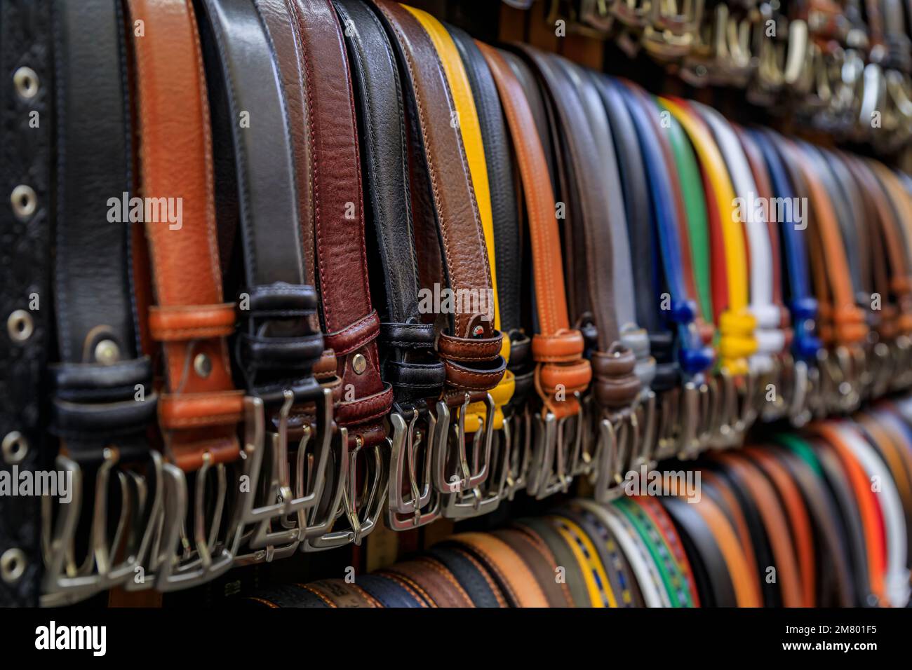 Colorful leather goods, selection of belts on display at a street shop in Central Market Mercato Centrale in Florence, Italy Stock Photo