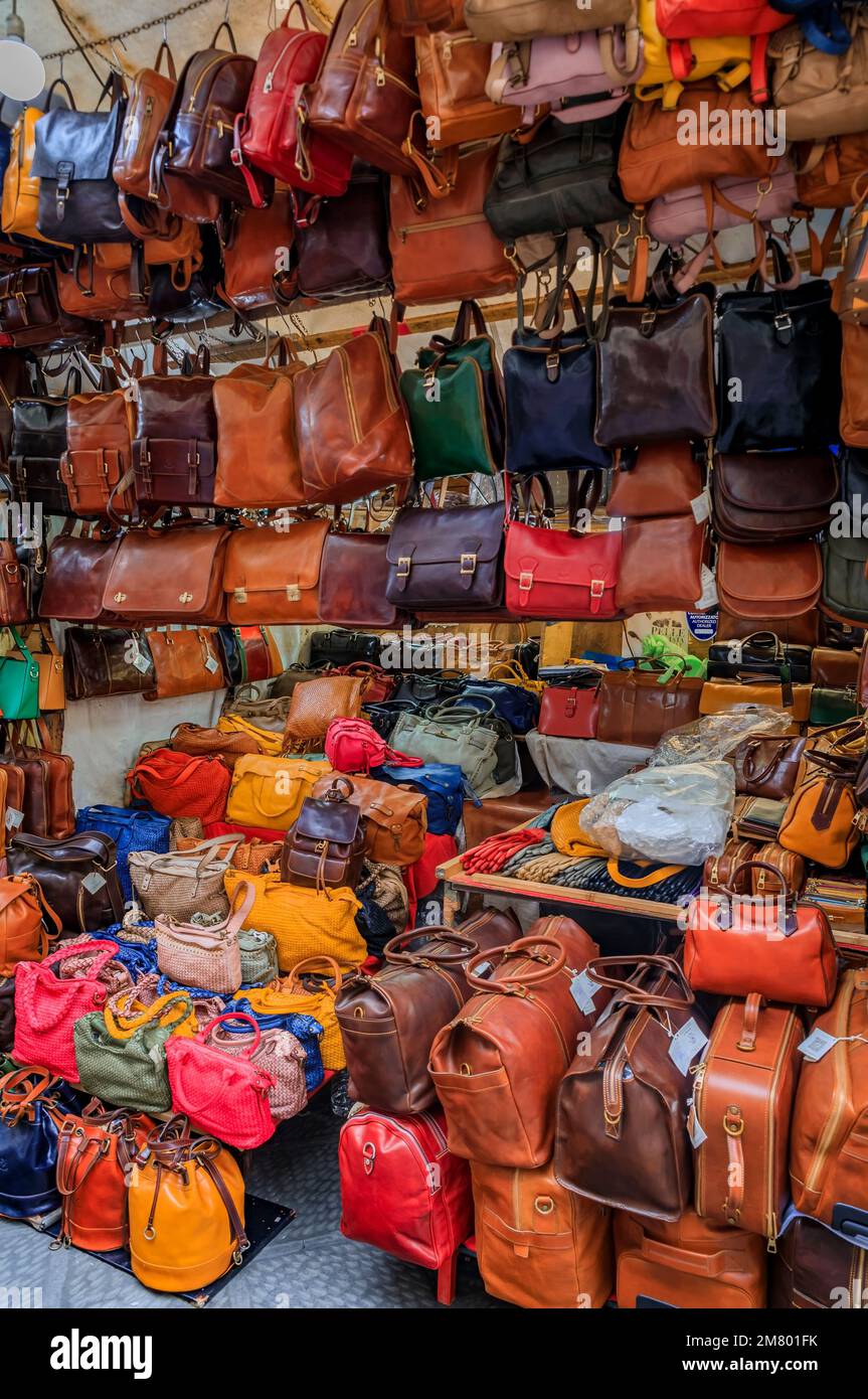 Florence, Italy - June 03, 2022: Colorful leather goods, bags and backpacks on display at a street shop in Central Market Mercato Centrale Stock Photo