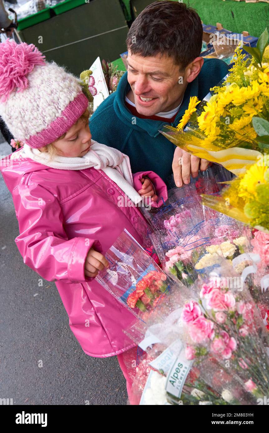 Adult male and young girl choosing a bouquet of flowers on the high street together Stock Photo