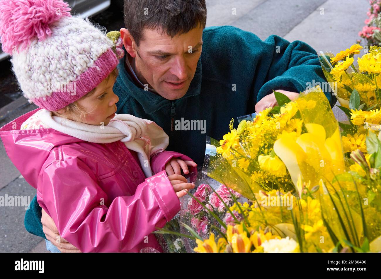 Adult male and young girl choosing a bouquet of flowers on the high street together Stock Photo