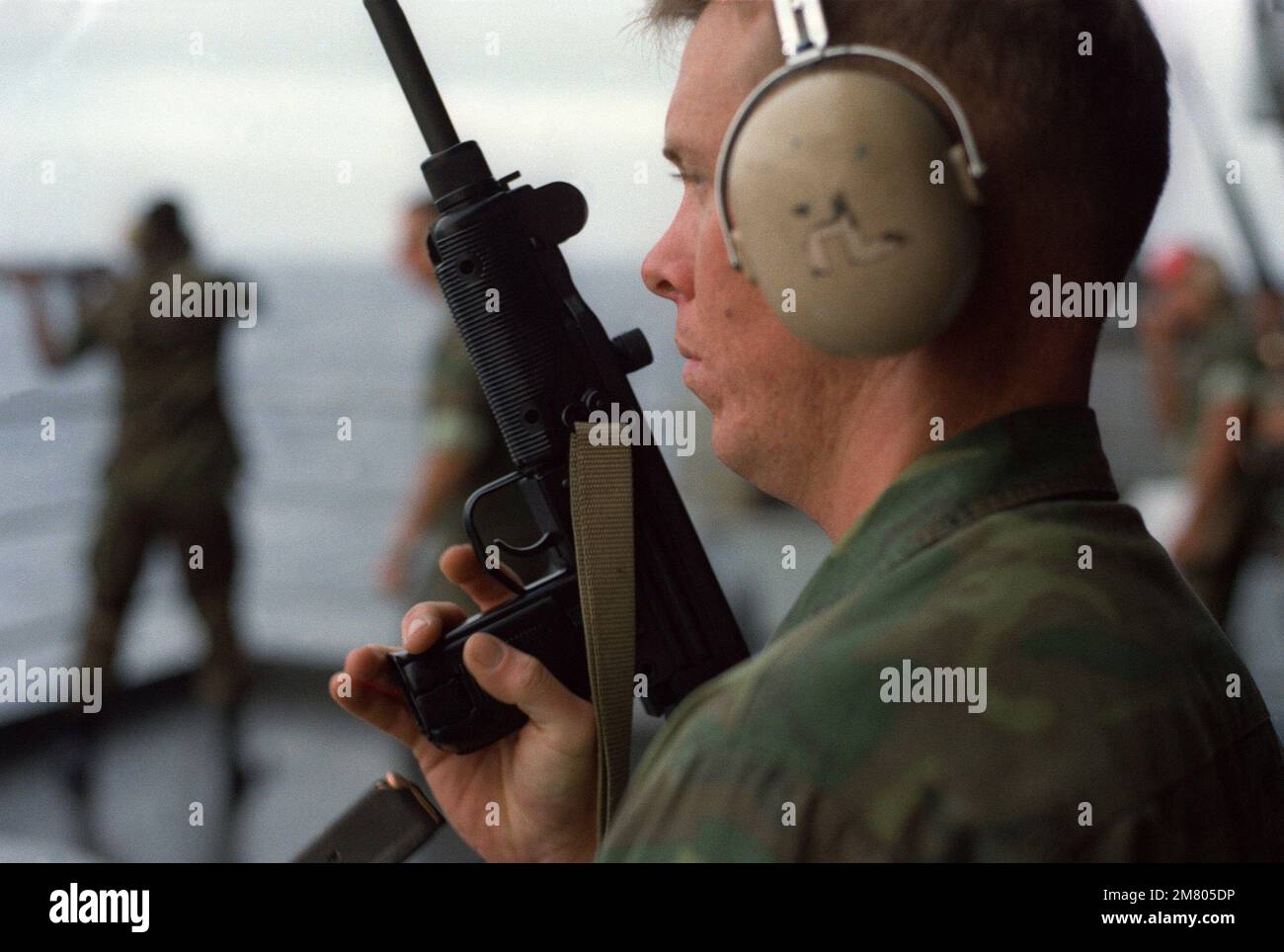 A Marine holds an Uzi 9 mm submarine gun during a familiarization weapons firing exercise on the fantail of the aircraft carrier USS KITTY HAWK (CV 63). Base: USS Kitty Hawk (CV 63) Stock Photo