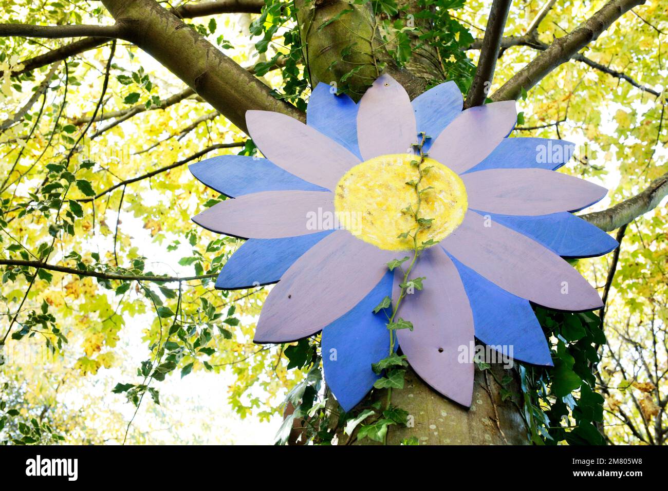 A large painted wooden flower in woodland near Redcar, North Yorkshire, UK. 02/11/2021 Photograph: Stuart Boulton Stock Photo