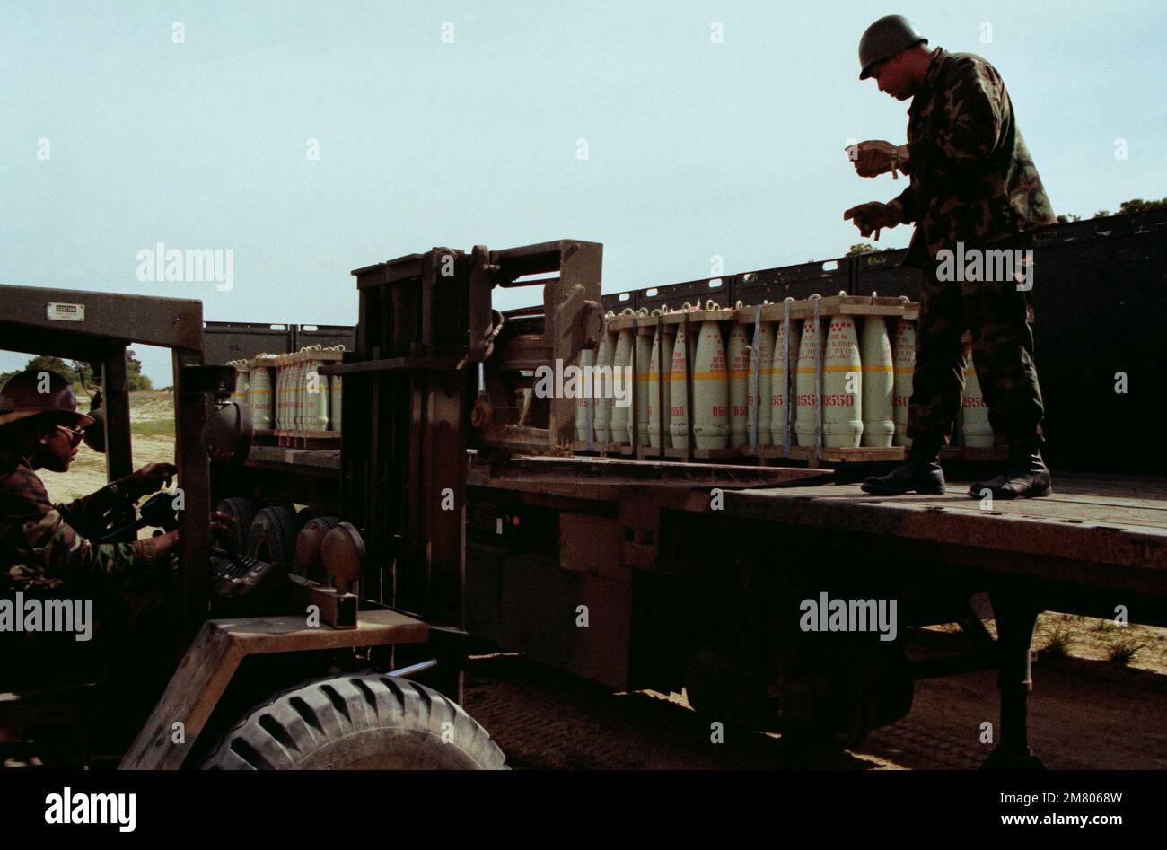 SPECIALIST 5 Johnson directs the operator of an RT-4000 forklift in ...