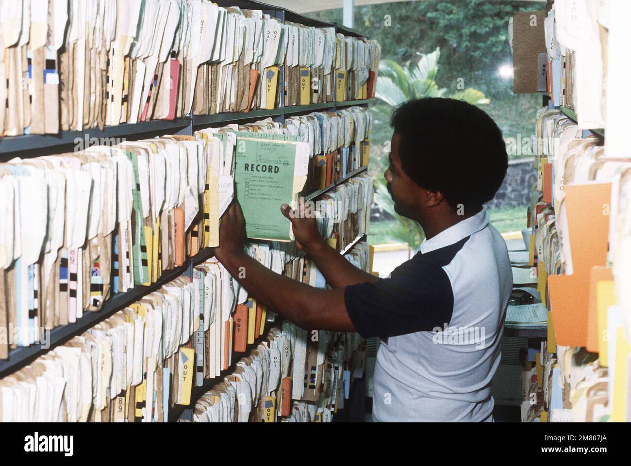 A medical records clerk pulls an outpatient medical records chart at