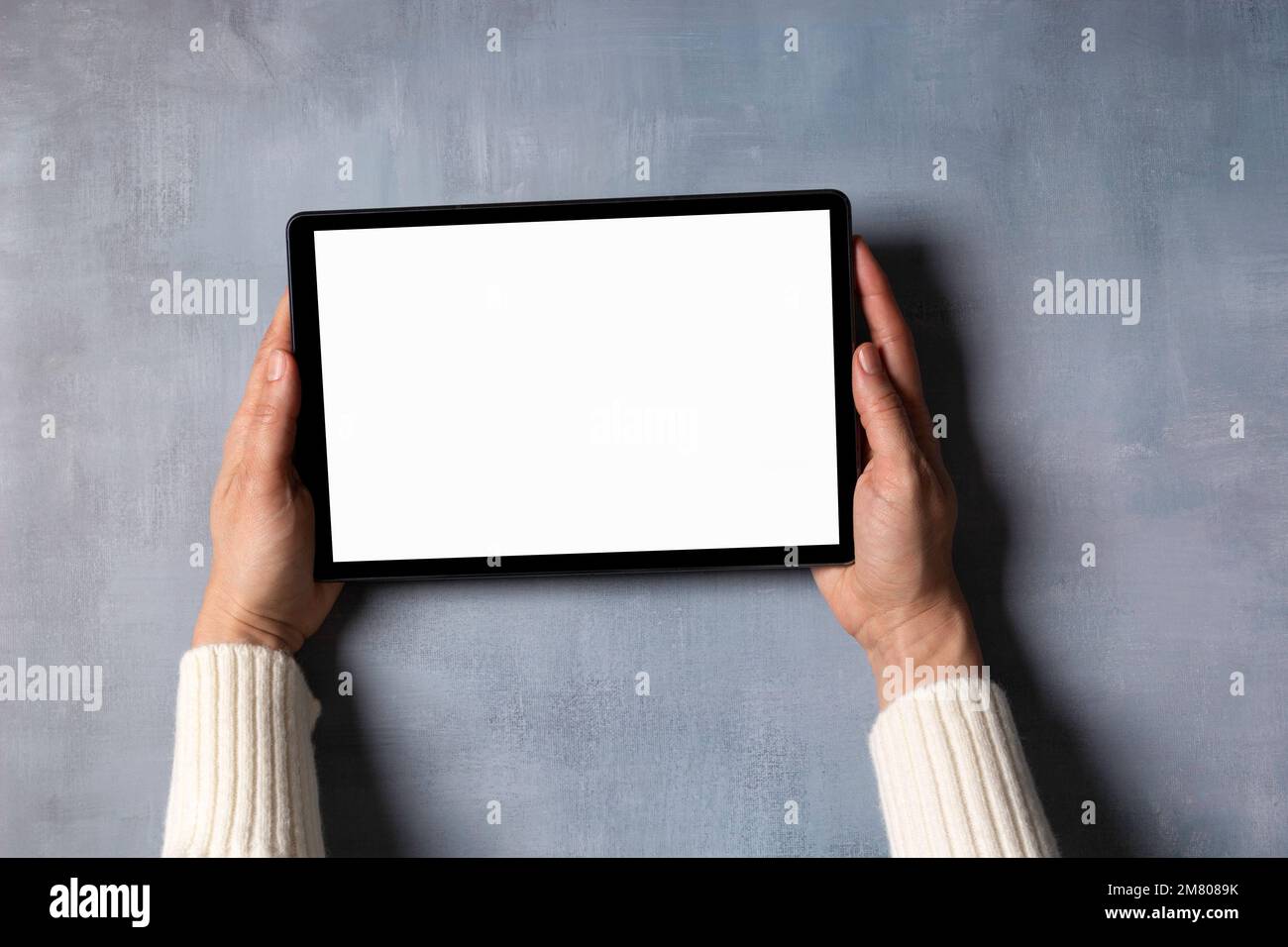 Woman hand holding digital tablet computer with blank white screen mock ...