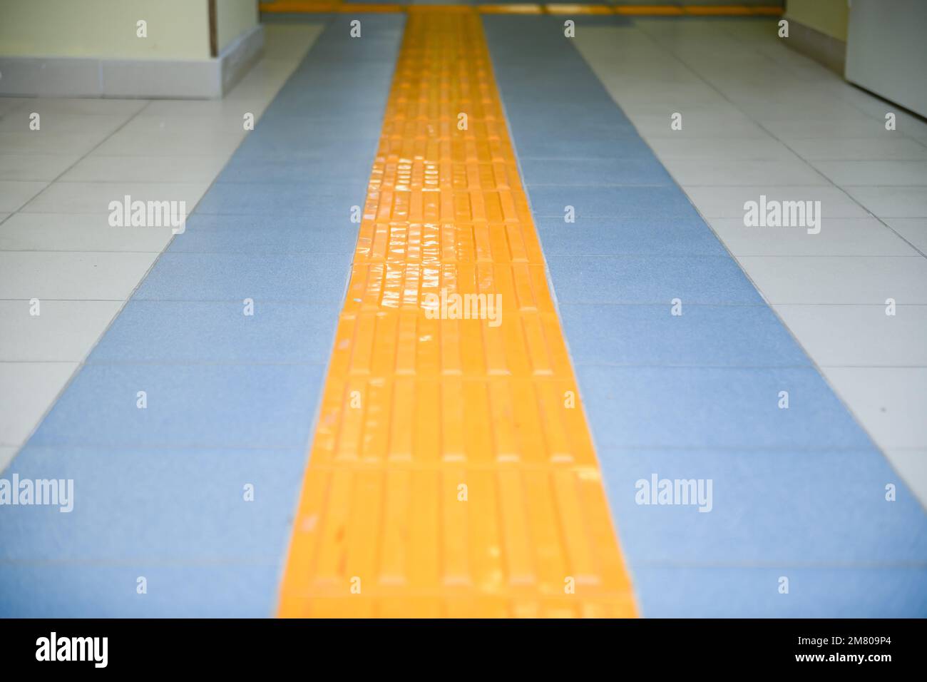 Perspective yellow tactile strip for cane or foot of blind person, close-up. Stock Photo