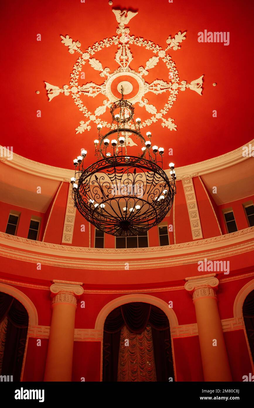 antique ceiling chandelier with lamps in red light on vaulted ceiling ...