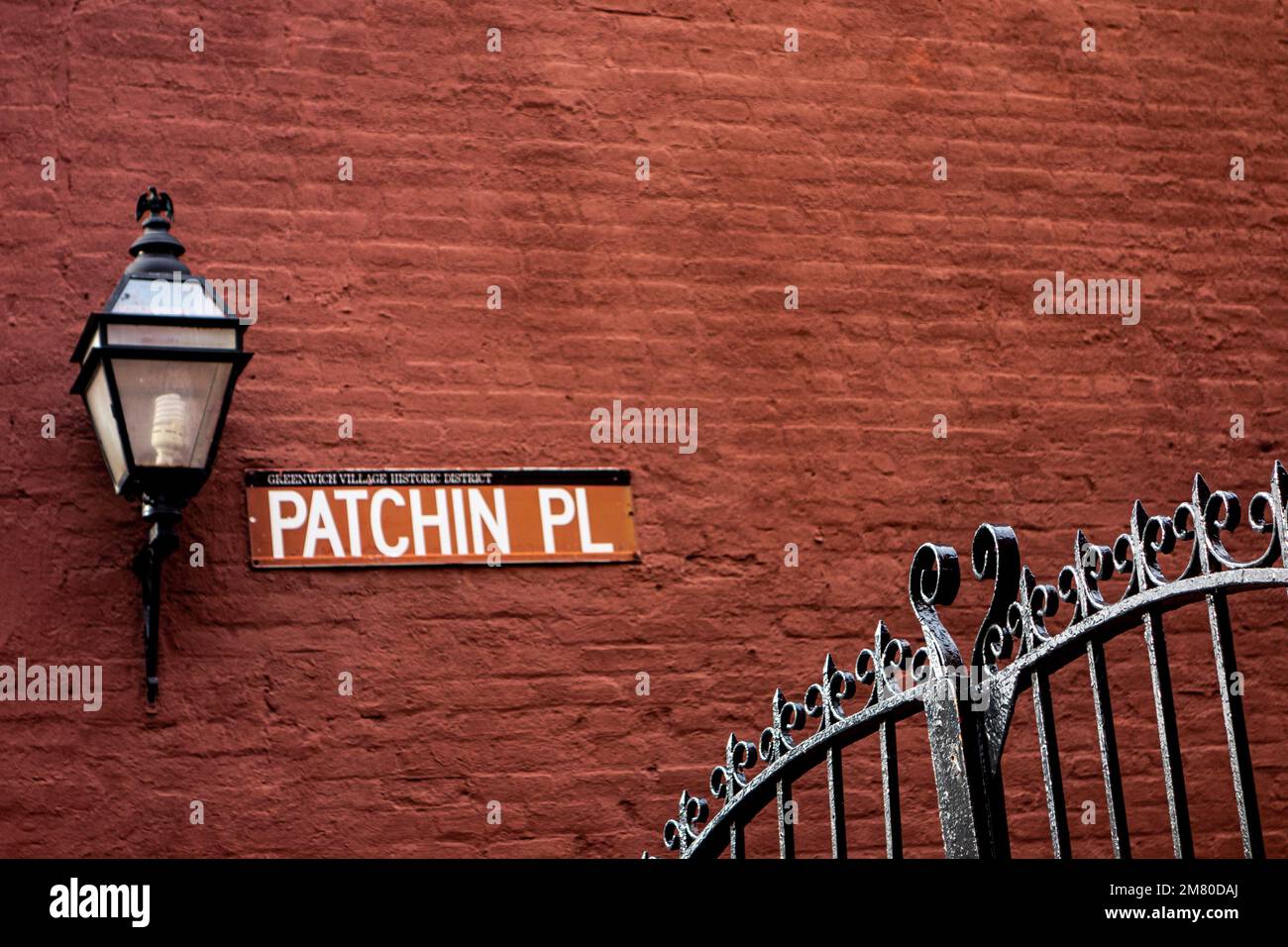 Lamp, sign and iron gate at Patchin Place, famous home of writers, E.E Cummings, Djuna Barnes and Theodore Dreiser, Greenwich Village, New York City Stock Photo