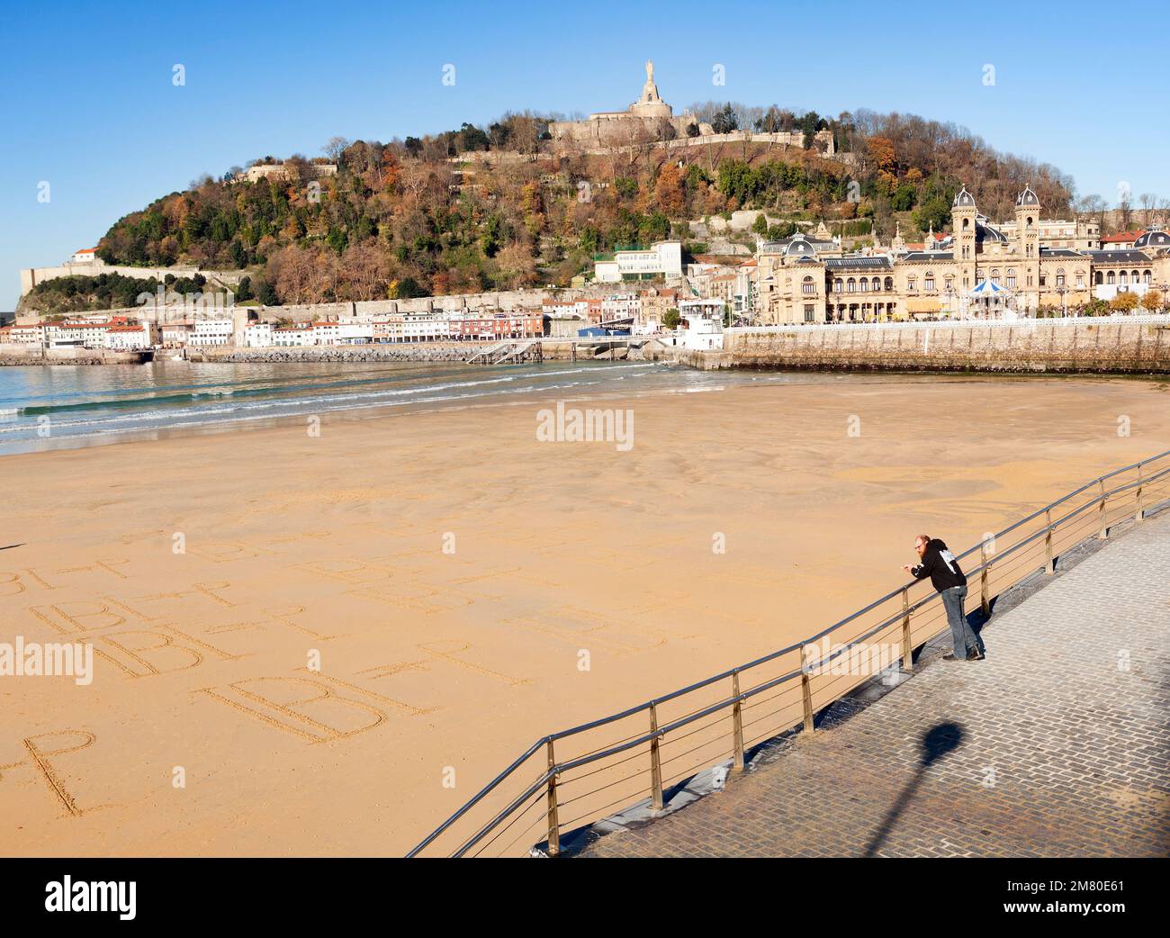 Donosti, Spain-December 22, 2014: On sunny days, the people of Donosti take the opportunity to stroll along La Concha Beach Stock Photo