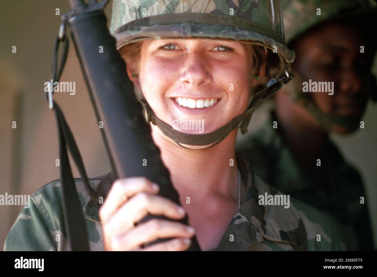 A female recruit awaits her turn to fire an M16A1 rifle during basic rifle marksmanship training. Base: Fort Dix State: New Jersey (NJ) Country: United States Of America (USA) Stock Photo