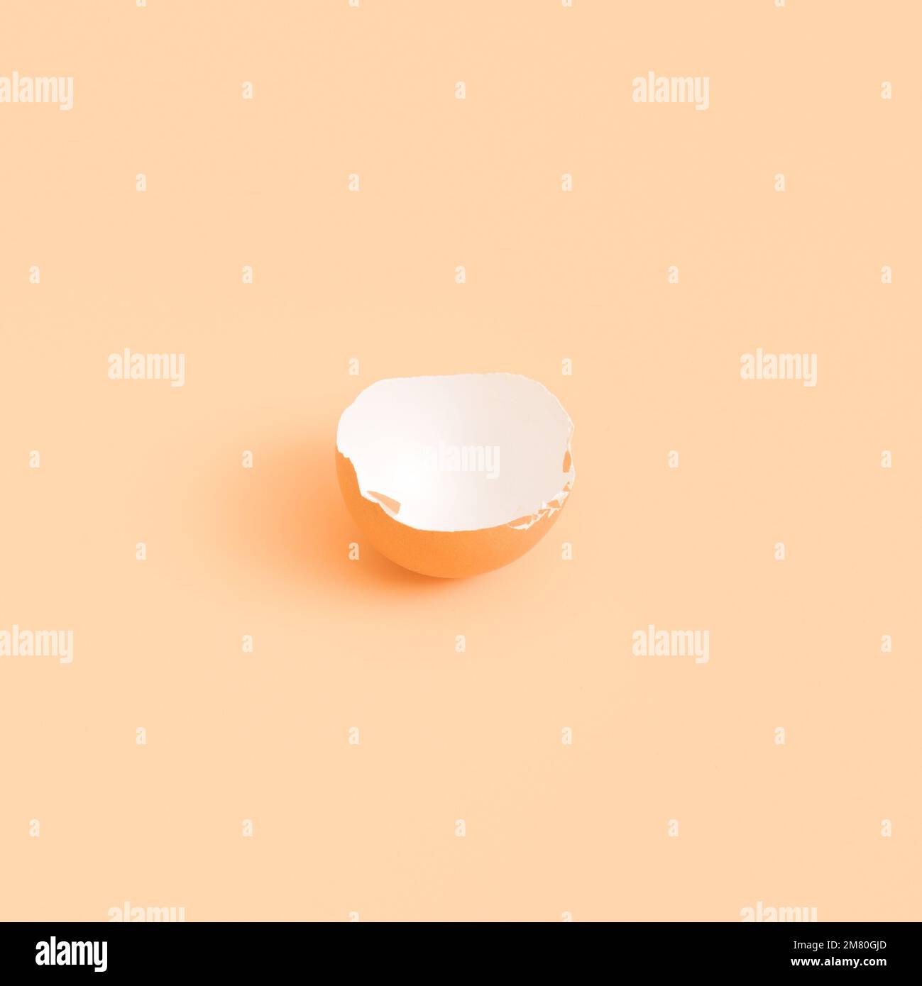 Half of an eggshell on a beige background. isolate Stock Photo