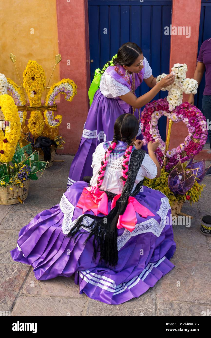 Chinas Oaxaquenas dancers decorate flower baskets to carry on their heads at the Guelaguetza festival in Oaxaca, Mexico. Stock Photo