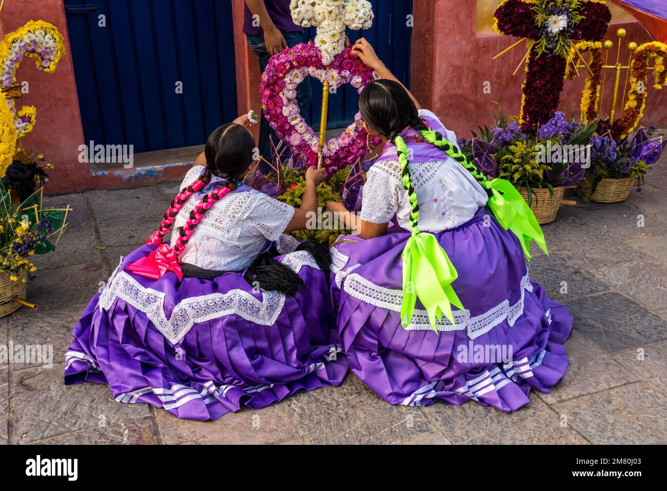 Chinas Oaxaquenas dancers decorate flower baskets to carry on their heads at the Guelaguetza festival in Oaxaca, Mexico. Stock Photo