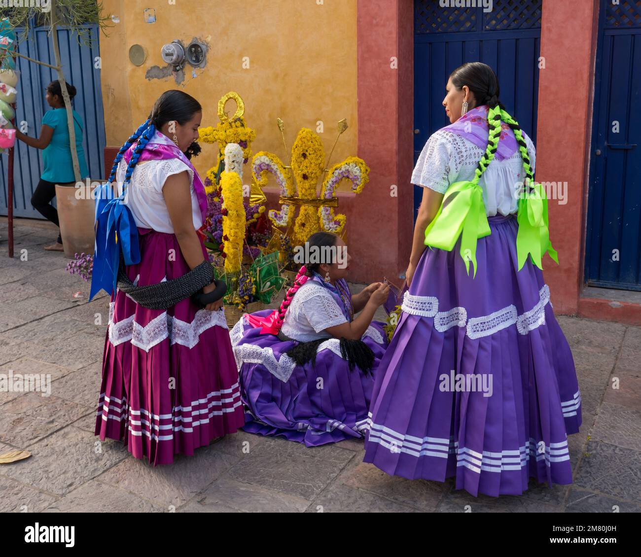 Chinas Oaxaquenas dancers decorate flower baskets to carry on their heads at the Guelaguetza festival in Oaxaca, Mexico. Stock Photo