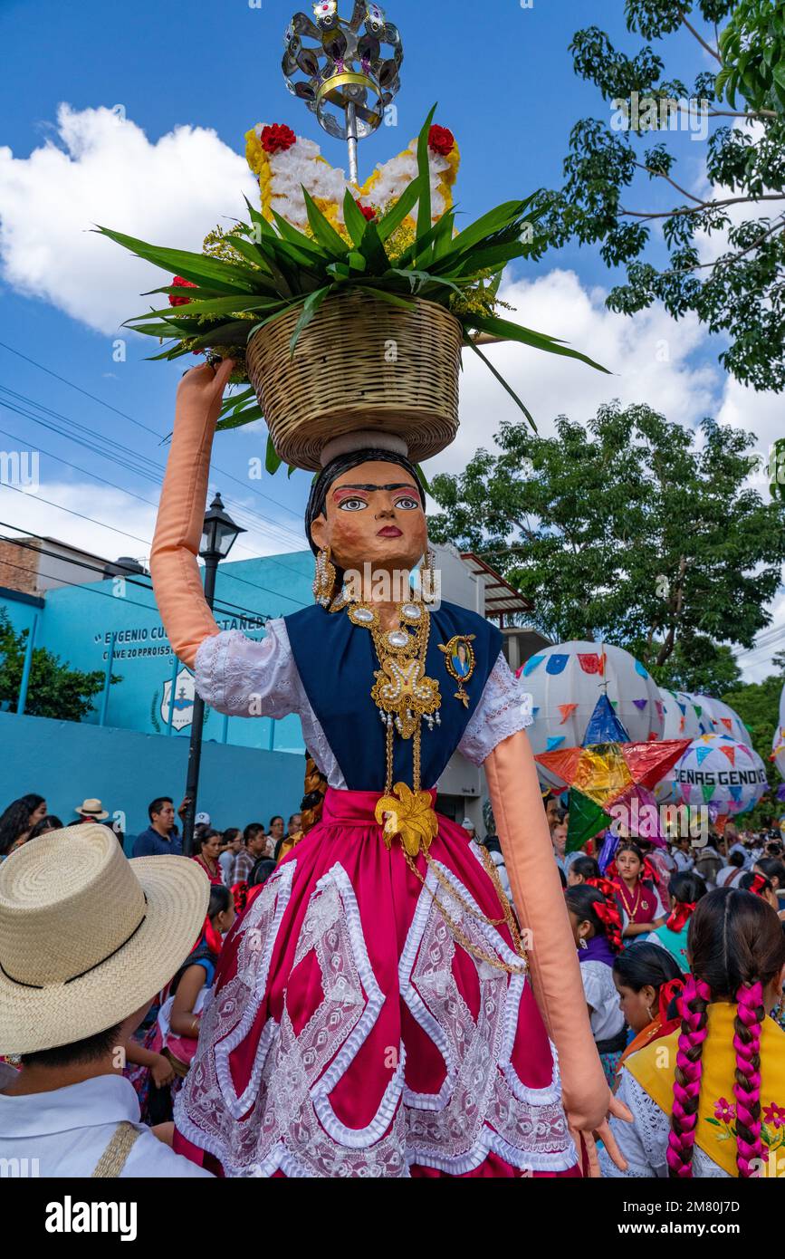 A farolero dancer with a large puppet of a Chinas Oxaquenas dancer at the Guelaguetza dance festival in Oaxaca, Mexico. Stock Photo