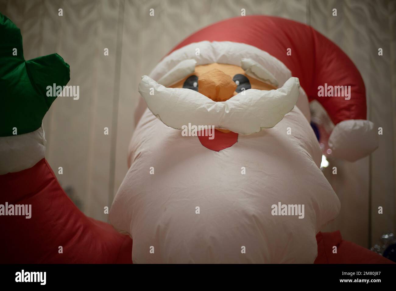 Inflatable Santa Claus. New Year game. Growth doll with air. Santa Claus waving his hand. Stock Photo