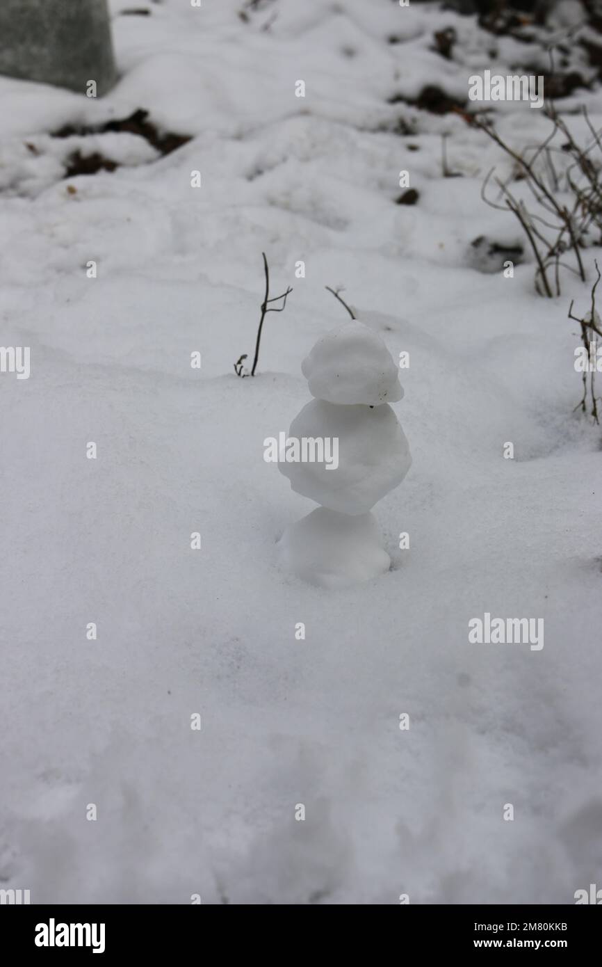 Snowman with carrot nose, and coal eyes mouth on snowy field Stock