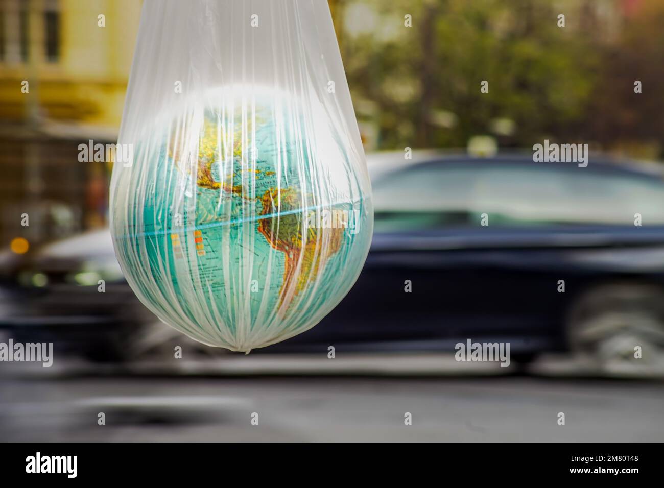A closeup of a globe in a transparent bag on the side of North and South America's map Stock Photo