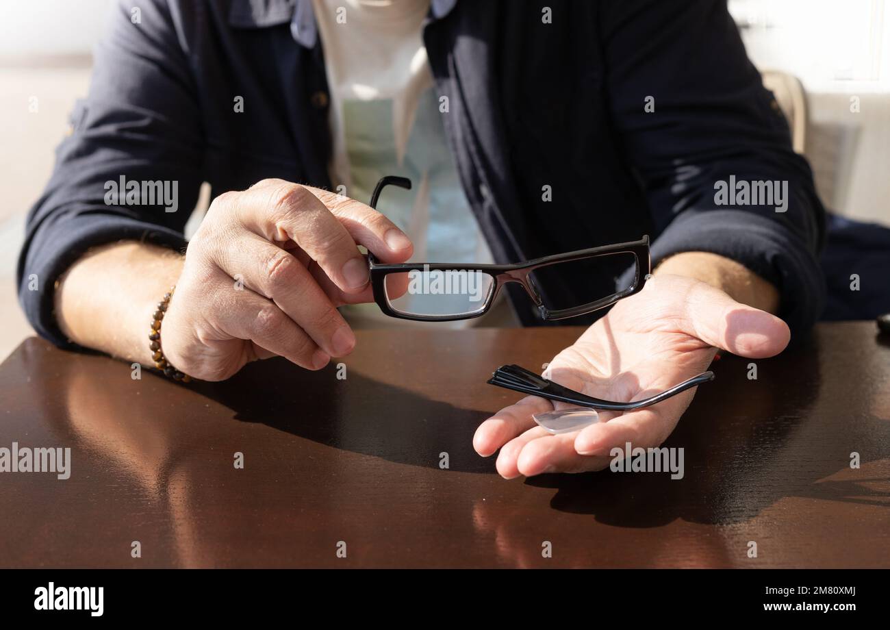 man's hands hold a broken eyeglass frame in the palms Stock Photo