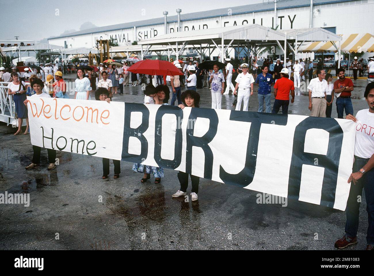 Family members display a home banner for a sailor aboard the