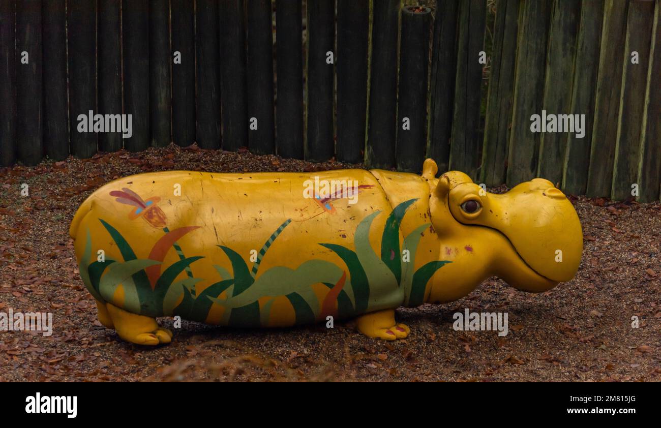 Climbing frame in zoo garden with big color yellow hippopotamus Stock