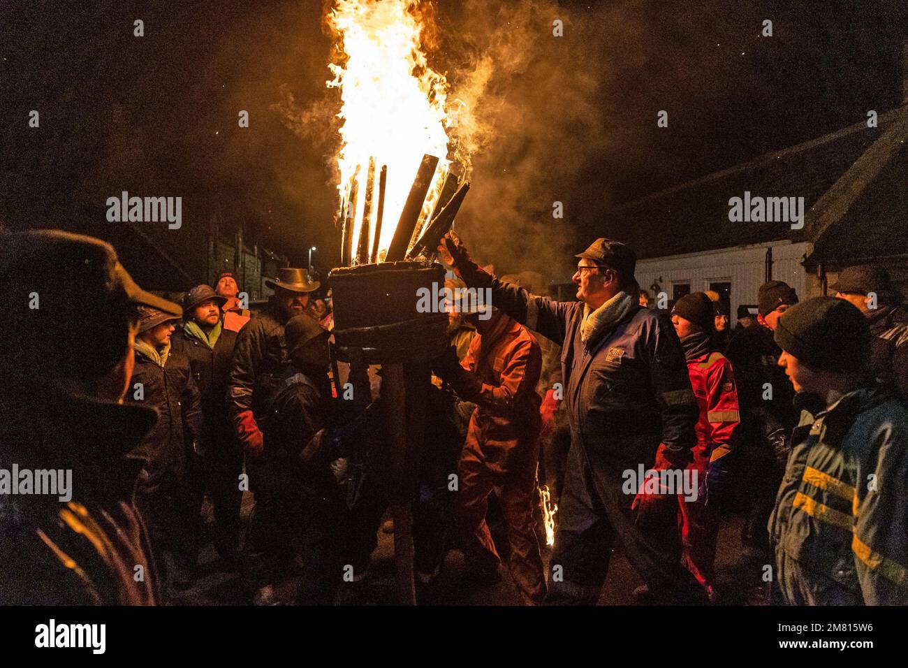 People carry a burning barrel of tar during the Burning of the Clavie, a  fire festival unique to Burghead in Moray, which greets the New Year twice,  on the 11th January and