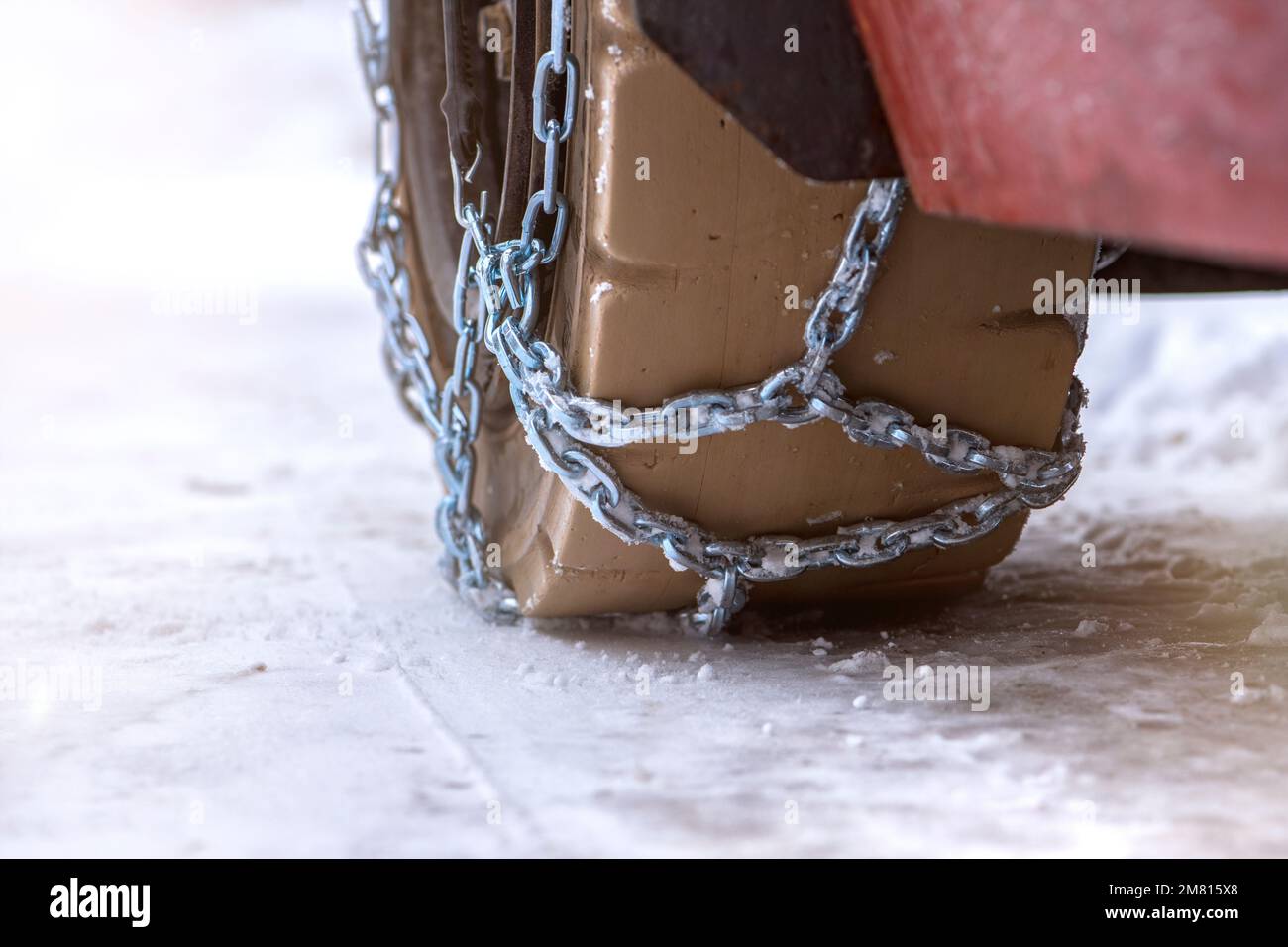 Wheel in the snow with safety and antiskid chains. Loader or tractor