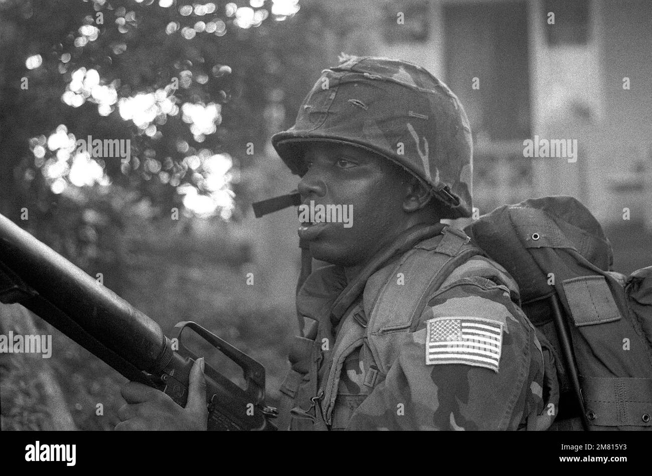 A Marine armed with M16A1 rifle patrols the area around Grenville during Operation URGENT FURY. Subject Operation/Series: URGENT FURY Base: Grenville Country: Grenada (GRD) Stock Photo