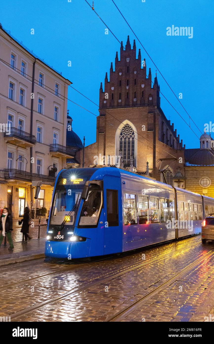 Krakow tram - Trams are the main local public transport system in Krakow Old Town, seen at night in front of the Dominican Church, Krakow, Poland tram Stock Photo