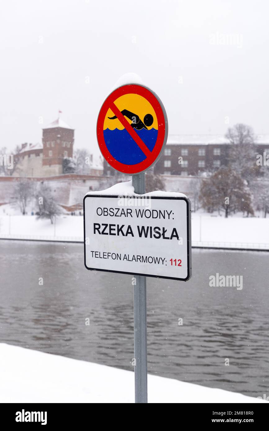 No swimming sign by a river in winter and snow all around. Concept Uninviting, Risky, Unpleasant, Dangerous. Vistula River Krakow Poland Stock Photo