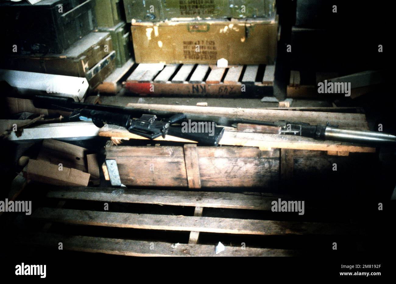 An M16A1 rifle is laid across crates containing Cuban weapons captured during Operation URGENT FURY. Subject Operation/Series: URGENT FURY Country: Grenada (GRD) Stock Photo