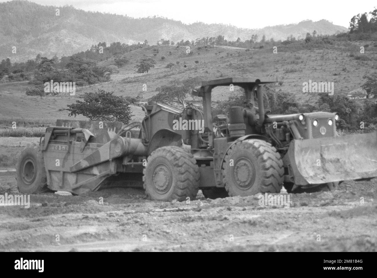 A bulldozer is used by the 46th Engineers to clear land for an airstrip during the AHUAS TARA II (BIG PINE) operation. Subject Operation/Series: AHUAS TARA II (BIG PINE) Base: Aguacate Country: Honduras (HND) Stock Photo