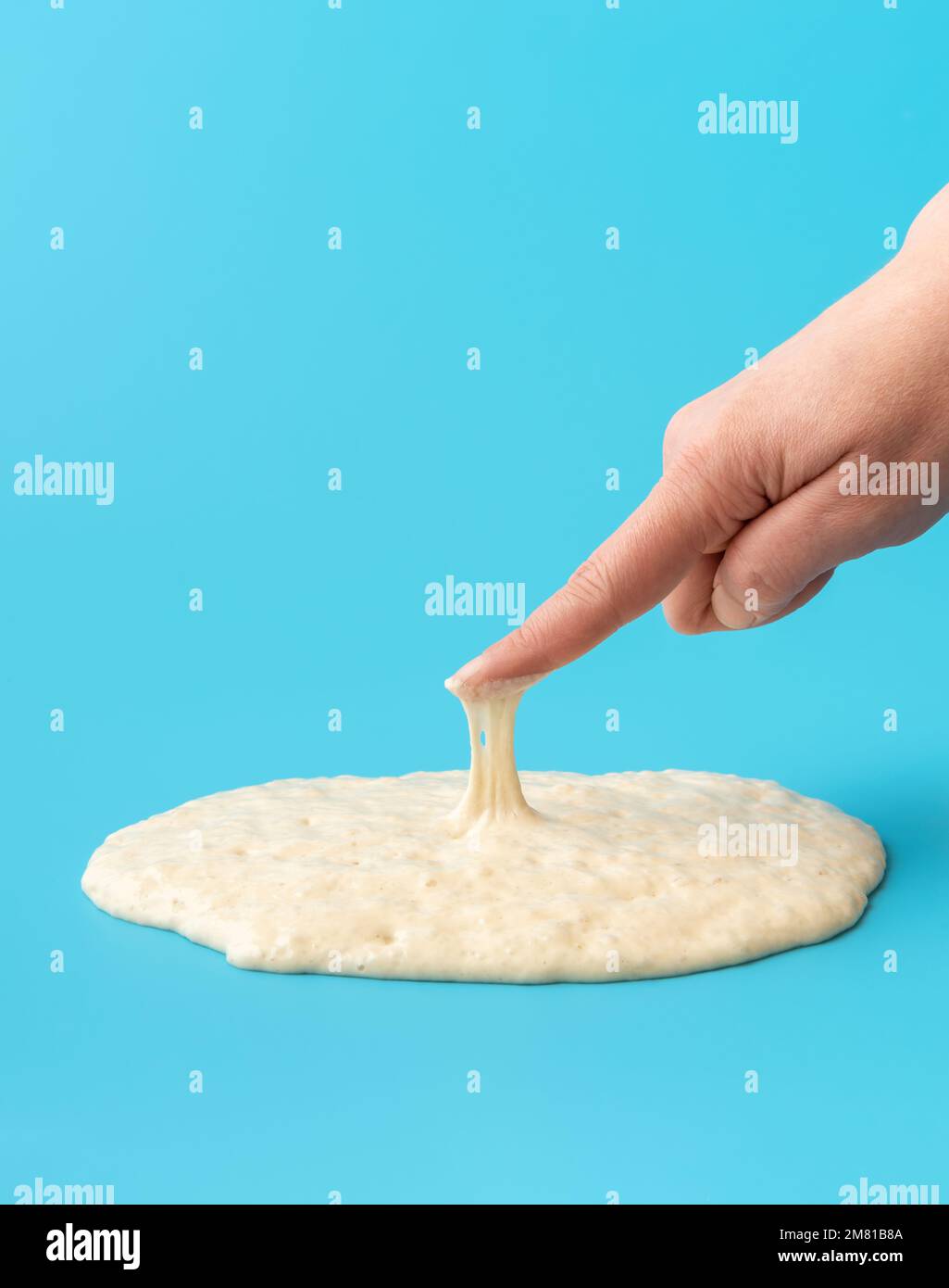 Woman is testing the sourdough yeast with one finger, minimalist on a