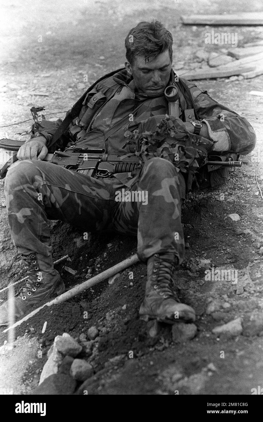 A soldier takes a break during Operation URGENT FURY. He is armed with an M203 grenade launcher mounted on an M16A1 rifle. Subject Operation/Series: URGENT FURY Country: Grenada (GRD) Stock Photo