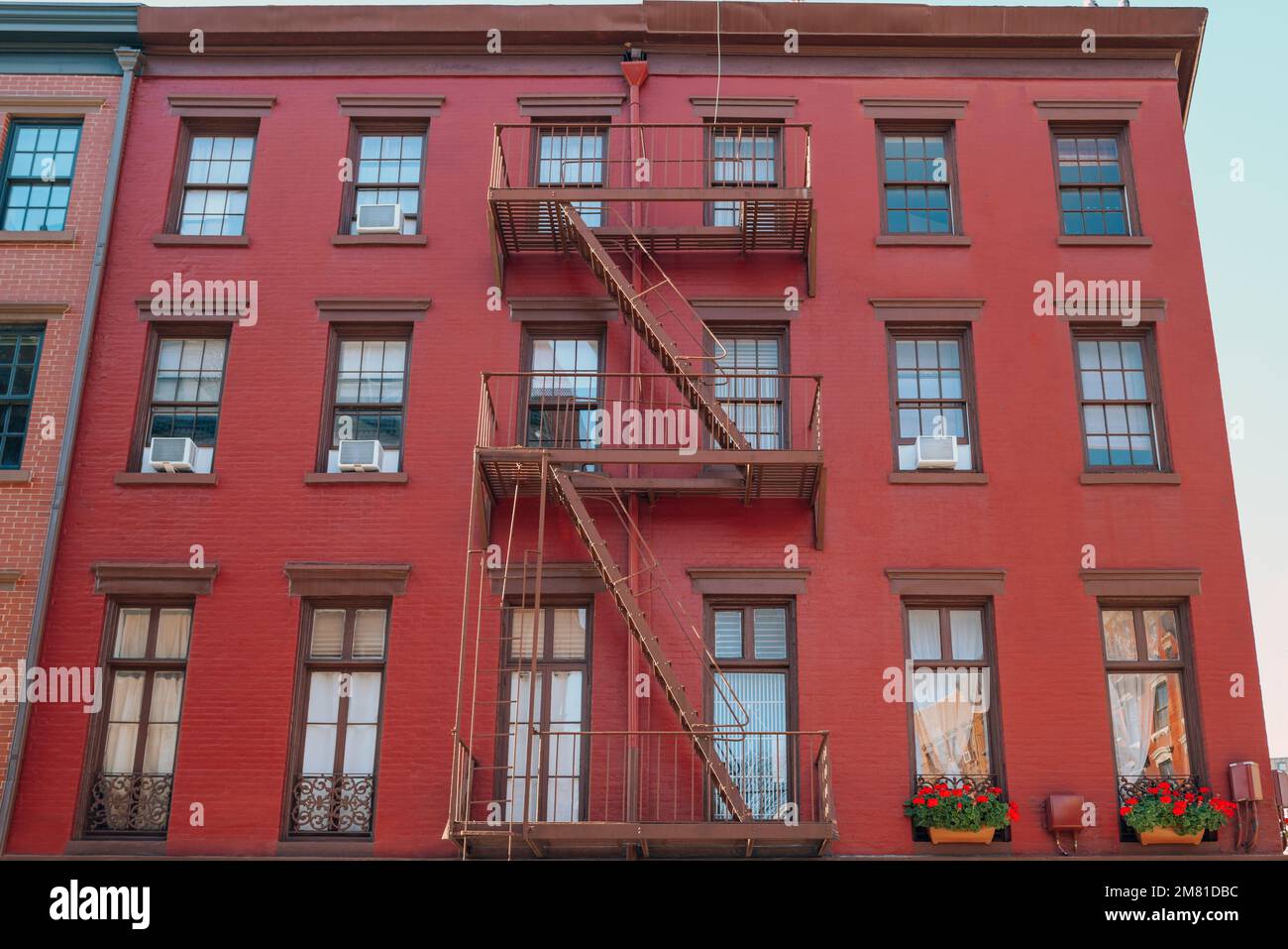 Facade of a red brick New York apartment block with fire escape at the
