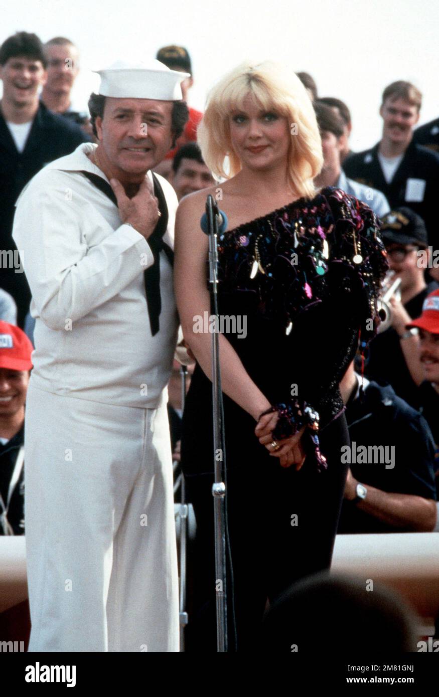 Entertainers Vic Damone and Ann Jillian perform for crewmen aboard the battleship USS NEW JERSEY (BB 62) during the Bob Hope USO Christmas show. The NEW JERSEY is operating off the coast of Beirut, Lebanon. Base: USS New Jersey (BB 62) Country: Mediterranean Sea (MED) Stock Photo