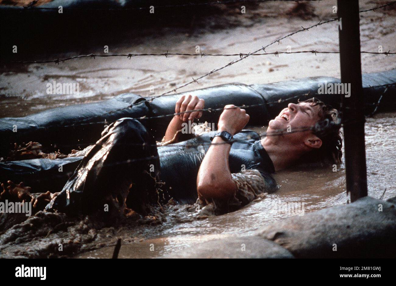AIRMAN on his back, in water and beneath barbed wire goes through one ...