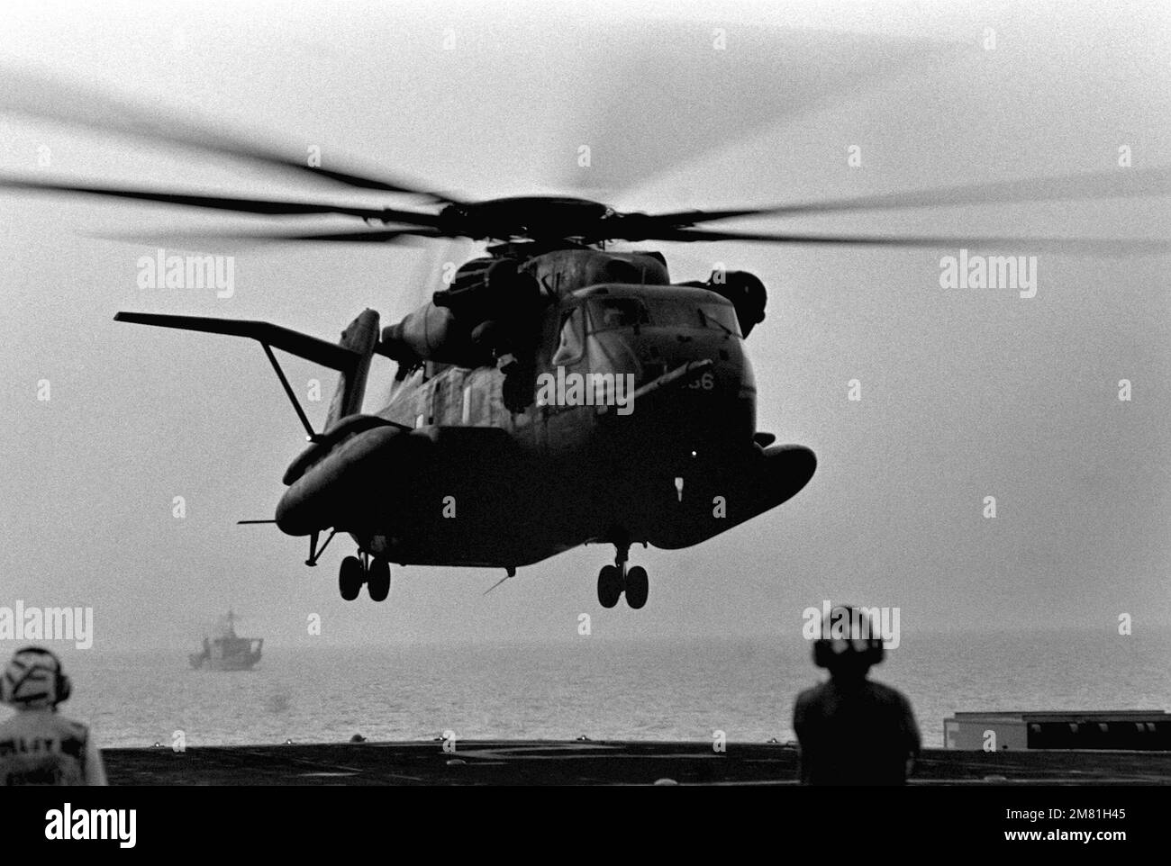 Flight deck crew members stand by as a Helicopter Combat Support ...