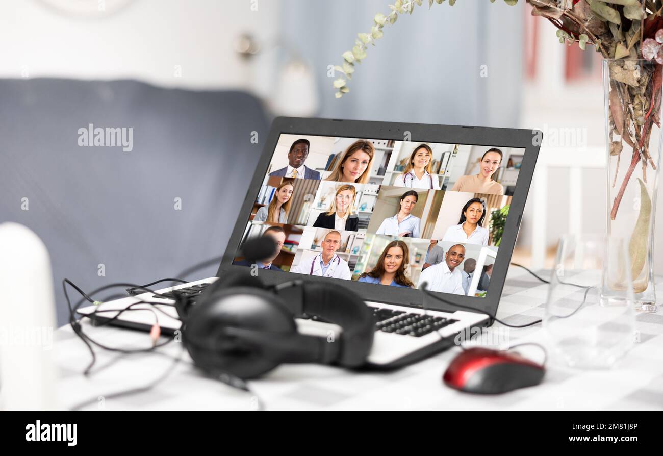 Laptop and headset on table at home, videoconference Stock Photo