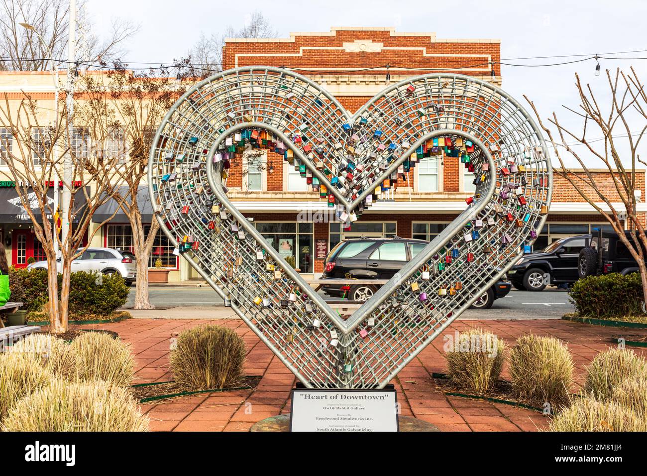 BURLINGTON, NC, USA-2 JAN 2023: The Paramount Theater setting behind a steel heart sculpture filled with engraved locks. Components of Sculpture furni Stock Photo