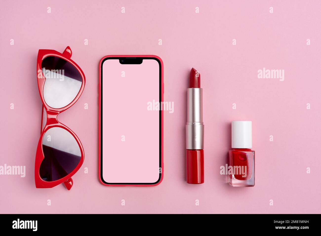 Set of sunglasses, phone, red lipstick and nail polish on pink background. Valentines day background Stock Photo