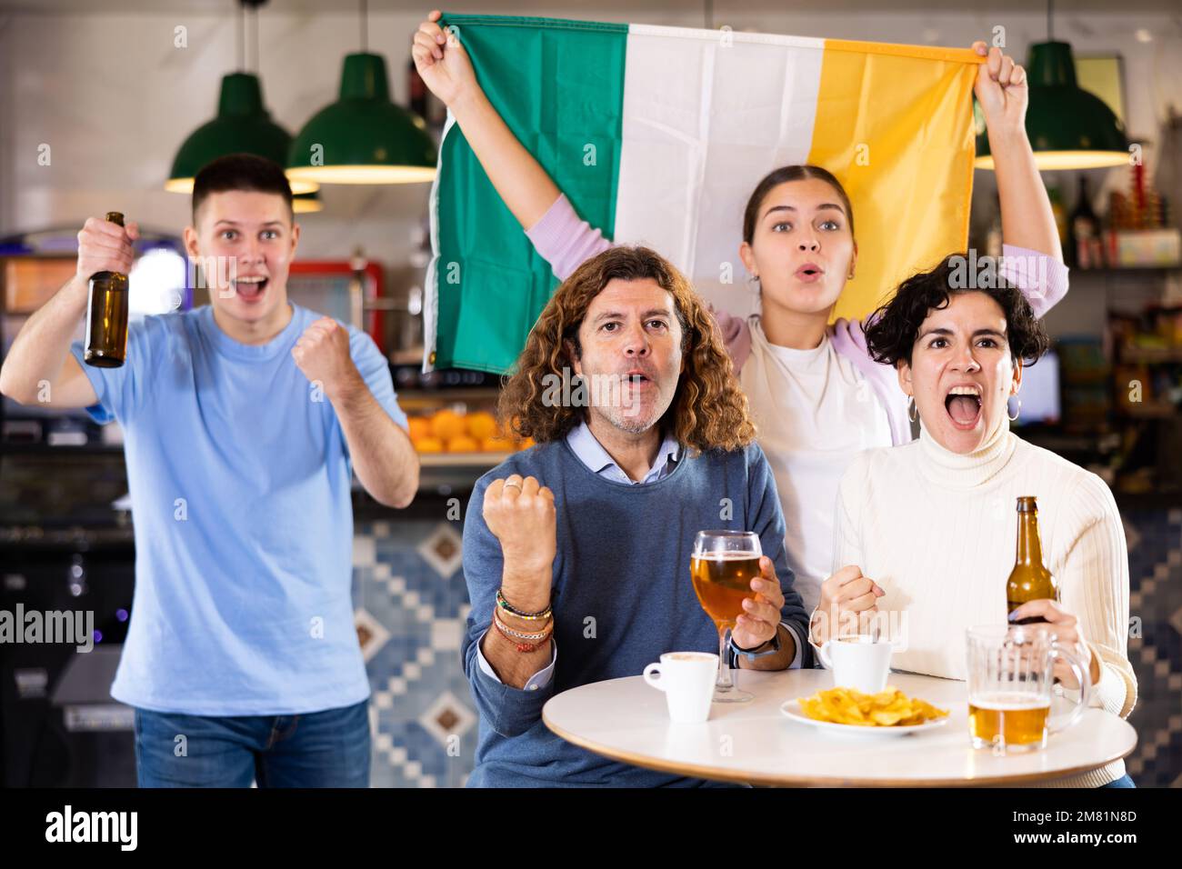 Group of excited fans friends rejoicing winning match game with Irish