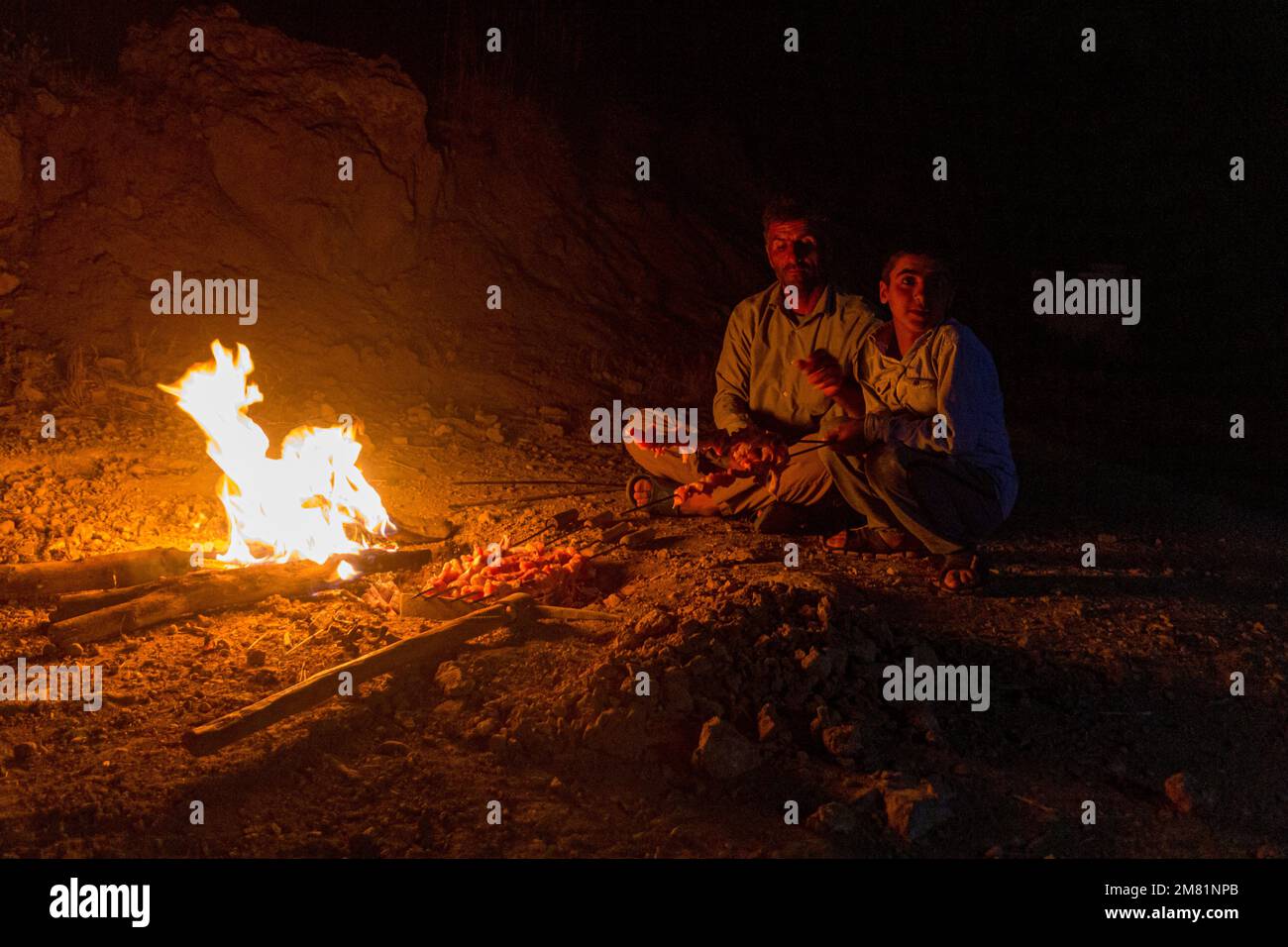 ZAGROS, IRAN - JULY 7, 2019: Nomad family having chicken barbecue in Zagros mountains, Iran Stock Photo