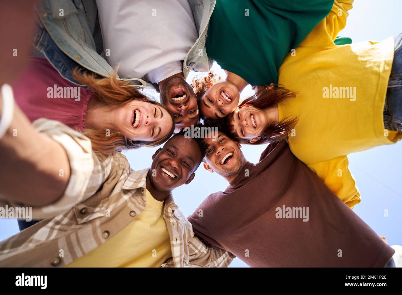 Internacional Erasmus students looking at camera cheerfully embracing each other. Stock Photo
