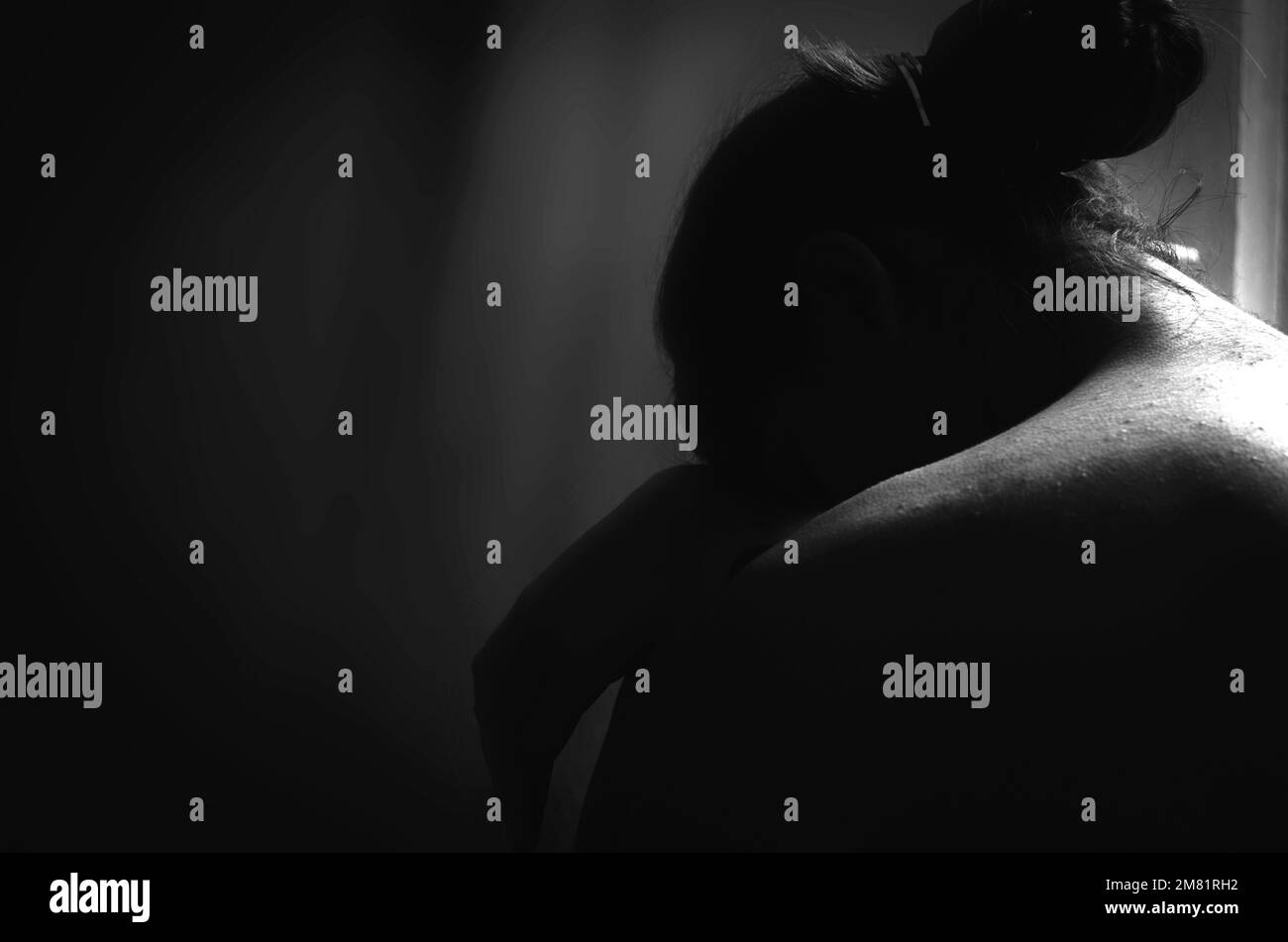 A greyscale back view of a crying female Stock Photo - Alamy
