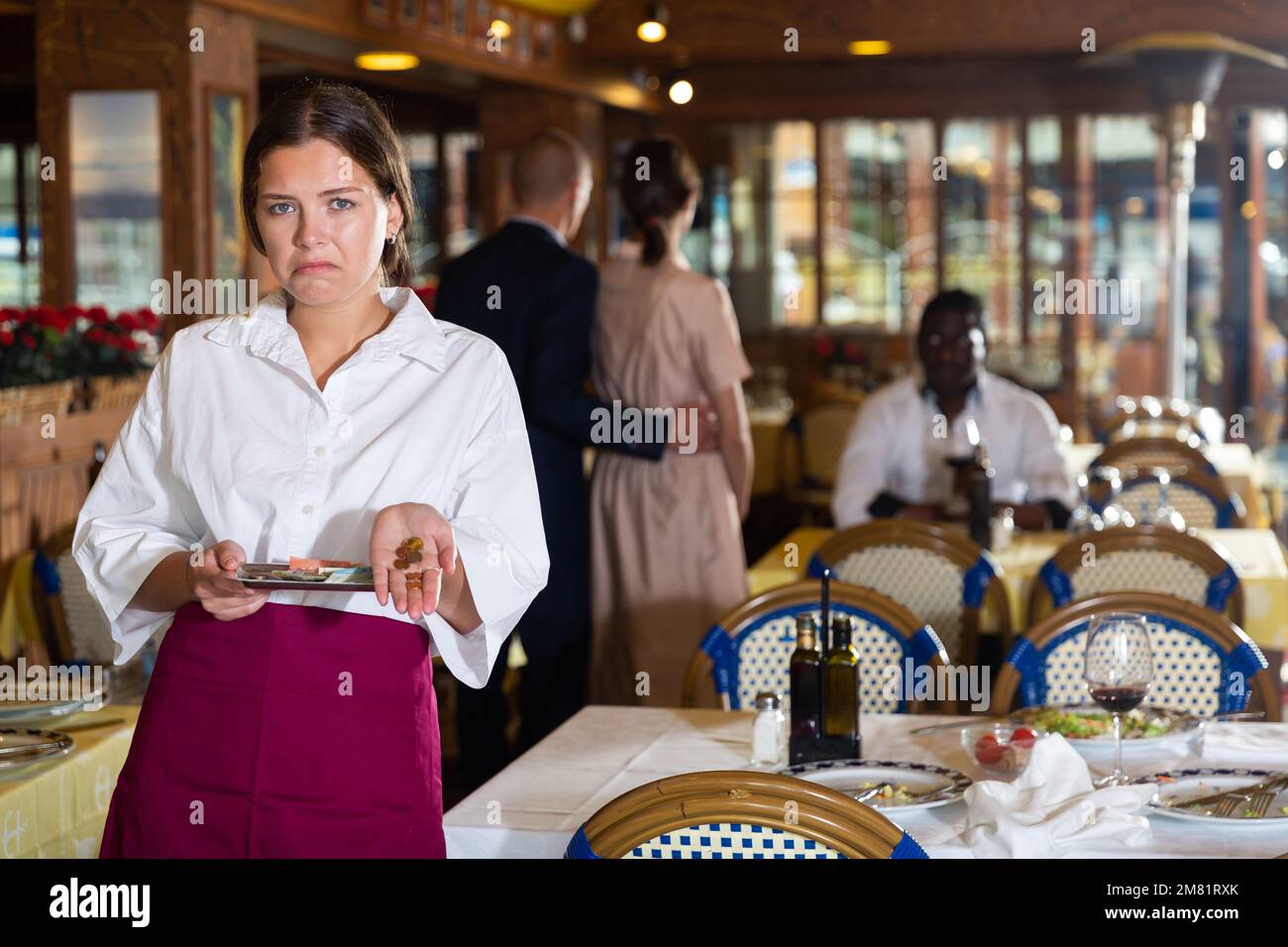 Woman waiter demonstrating her upset with small tip Stock Photo