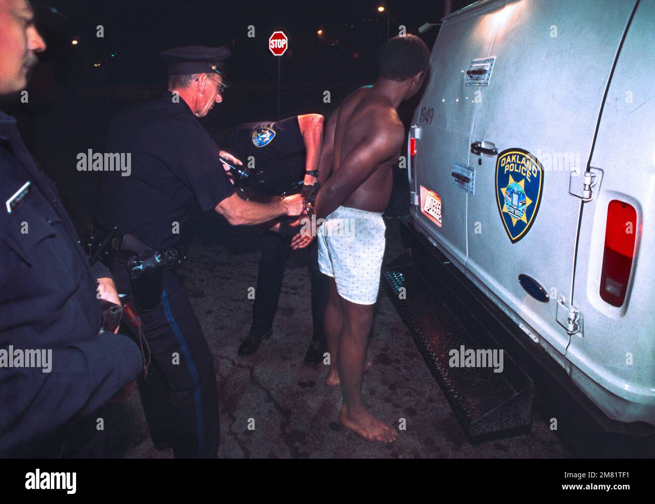 Black male being arrested by three Caucasian police officers in Oakland California. Stock Photo