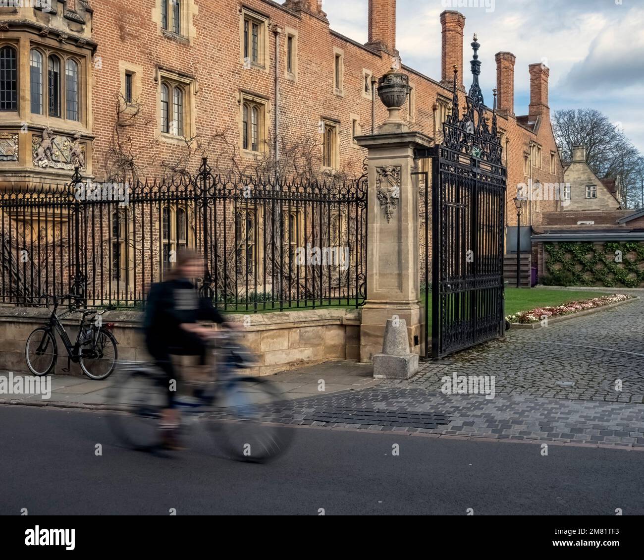 CAMBRIDGE, UK - MARCH 11, 2020: Cyclist passing Magdalene College building with motion blur Stock Photo