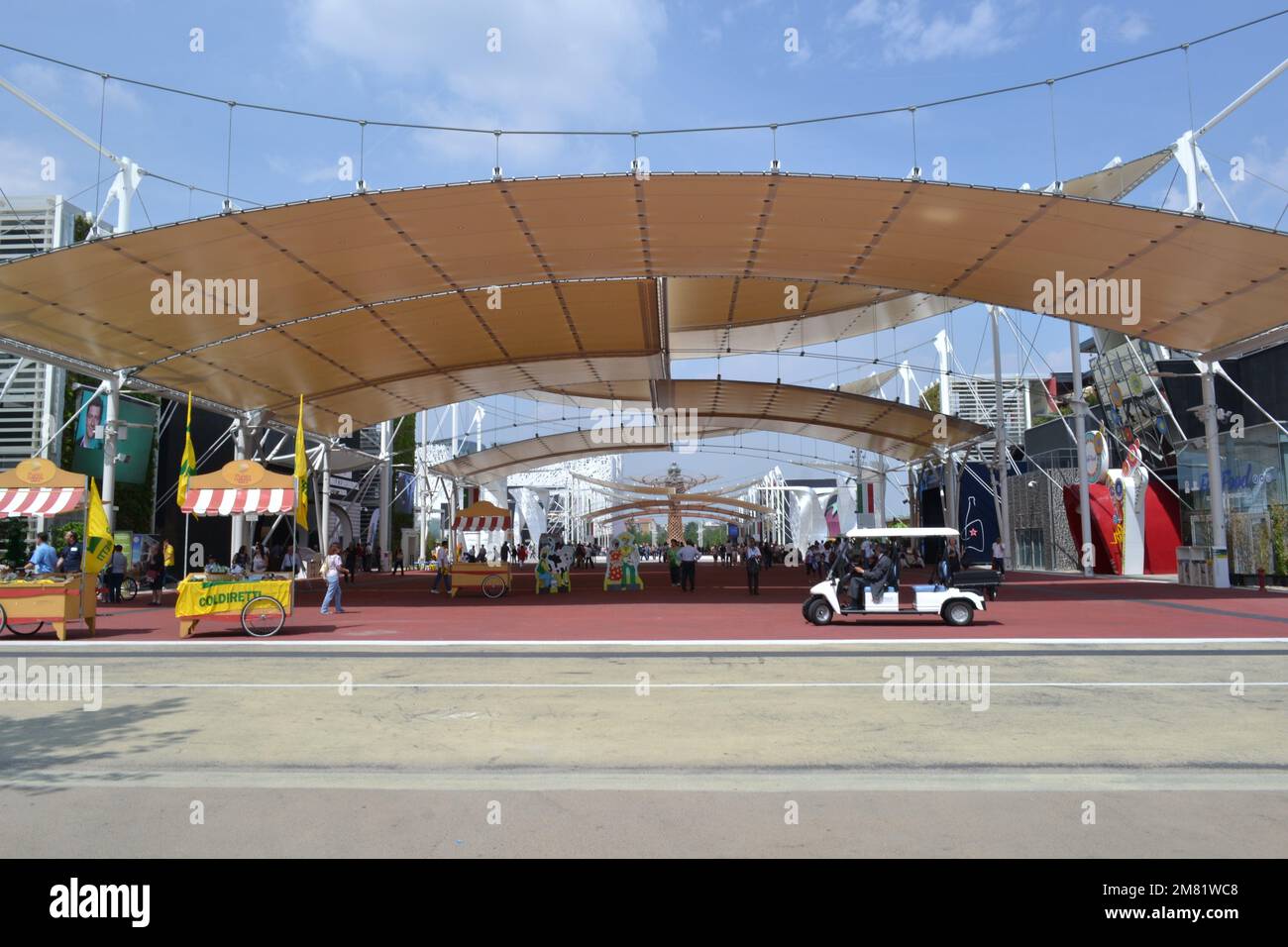 Panoramic view of the Italian cluster of Expo Milan 2015 and Cardo and Decumano street covered with tents. Italian food kiosks and a minibus. Stock Photo